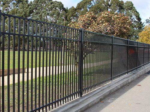 Long black powder coated fence running along a park reserve boundary