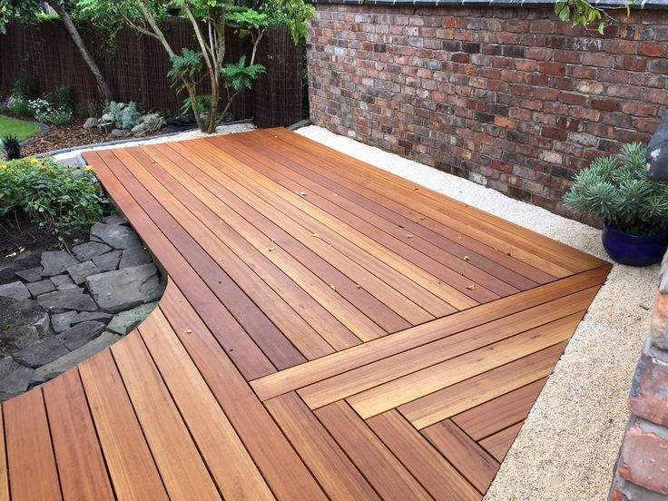 Hardwood deck with a mitred border laid against a brick courtyard wall
