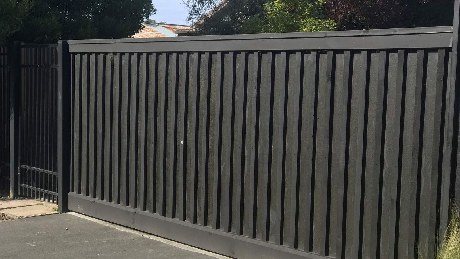 Black aluminium slat sliding driveway gate at a Christchurch property