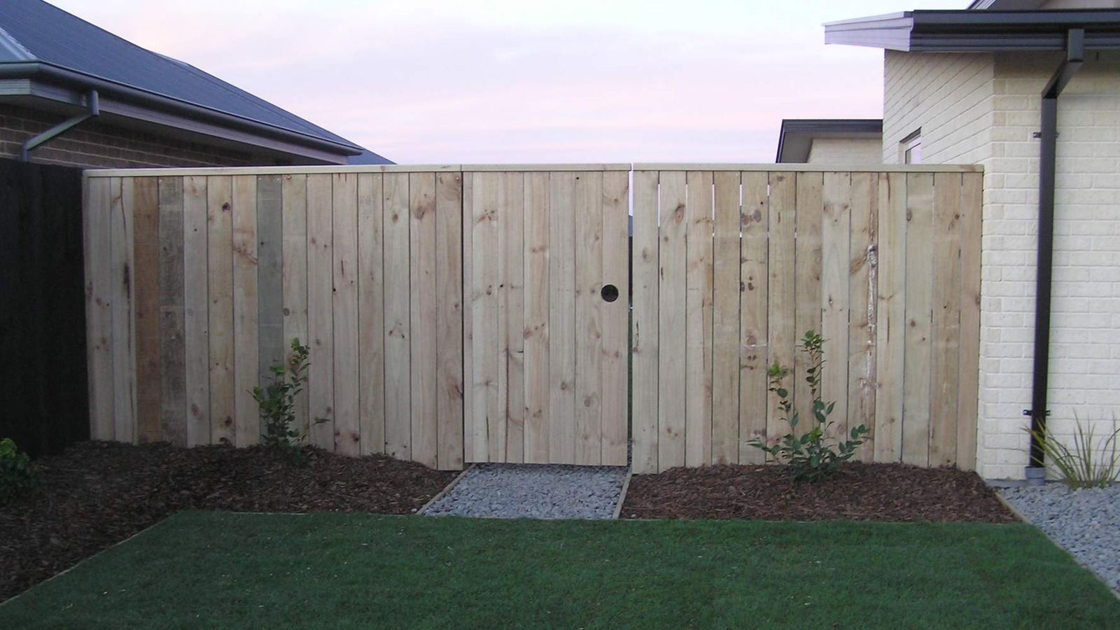 Finished vertical timber boundary fence and gate beside a new Christchurch home