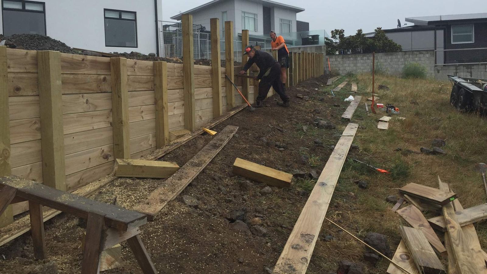 Timber retaining wall being built with H5 poles on a Christchurch section