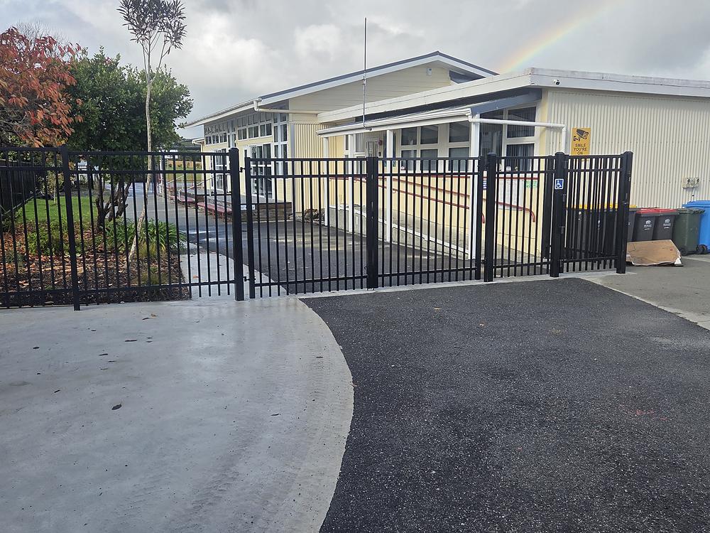 Black steel gates and matching fence at a school entrance